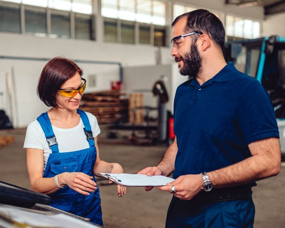 Consulenti Lean Sintesia - immagine di un consulente in polo che parla con una dipendente