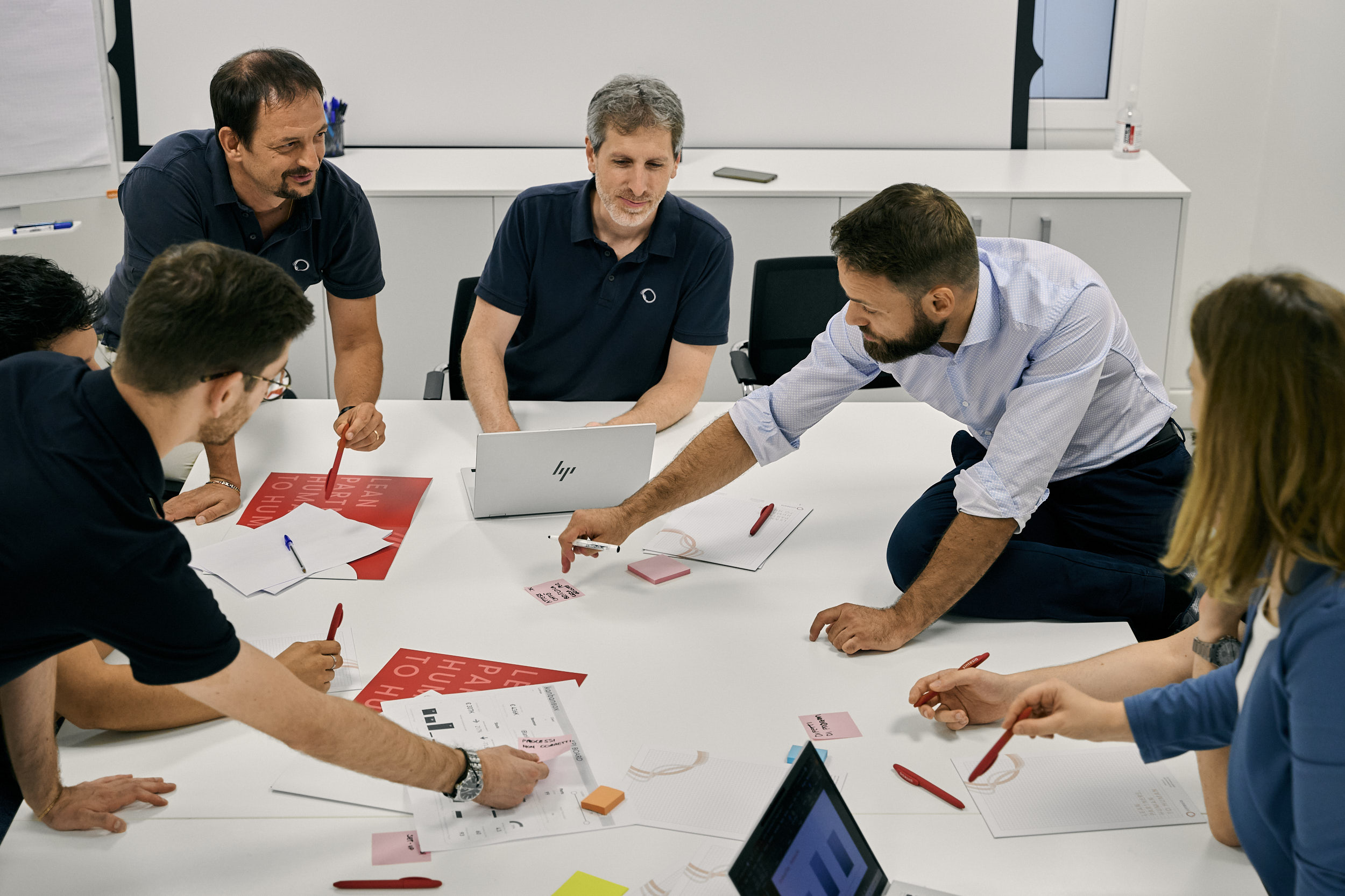 Consulenti Lean di Sintesia in riunione per un progetto seduti attorno ad un tavolo